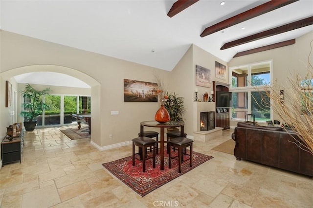 41565 Avenida Conchita, Murrieta, CA 92562 - dining room featuring arched walkways, stone tile flooring, plenty of natural light, beam ceiling, and a multi sided fireplace