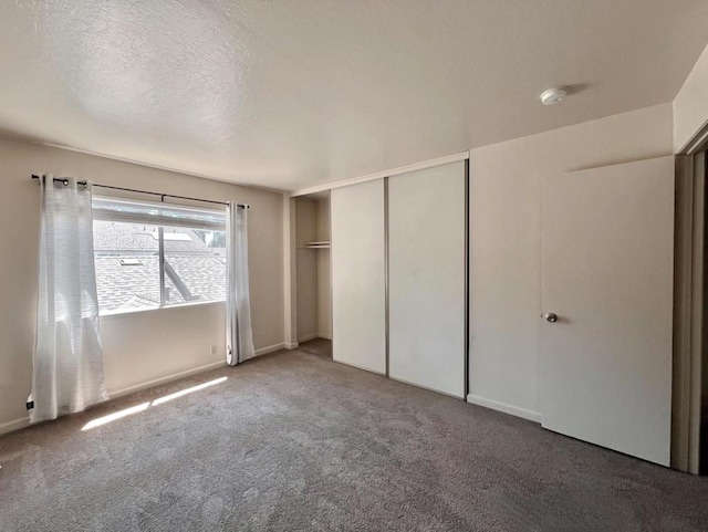 unfurnished bedroom featuring a textured ceiling, carpet floors, and a closet