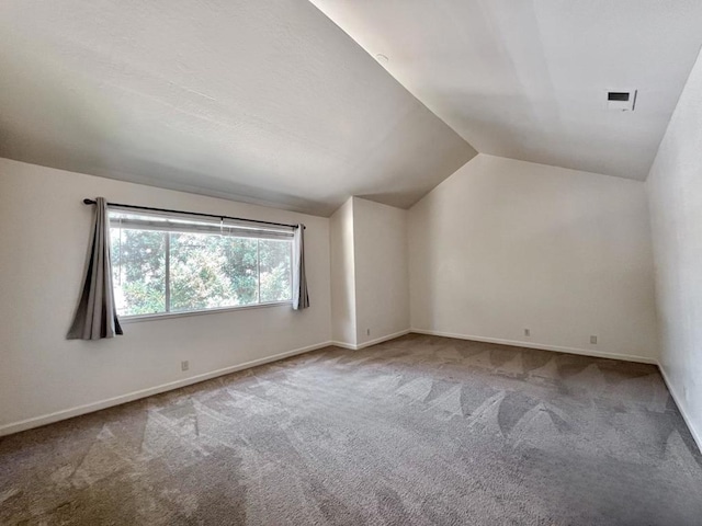 bonus room with vaulted ceiling and carpet