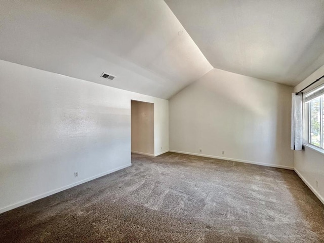 interior space with carpet floors and vaulted ceiling