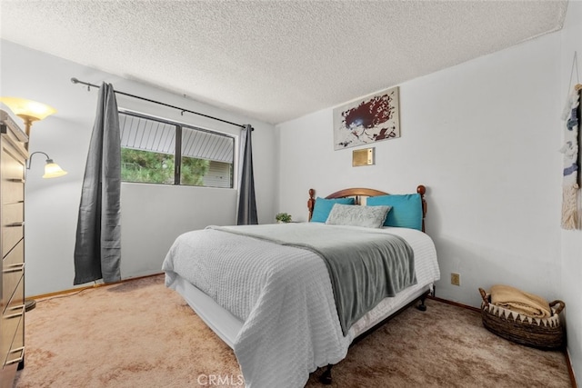 bedroom with carpet, baseboards, and a textured ceiling