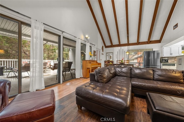 living area with high vaulted ceiling, wood finished floors, and beamed ceiling