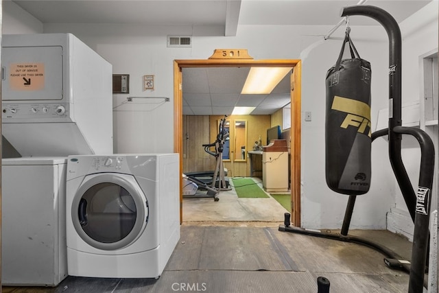 clothes washing area featuring laundry area, visible vents, and stacked washer and clothes dryer