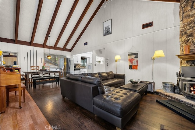 living room with high vaulted ceiling, a fireplace, beamed ceiling, and hardwood / wood-style flooring