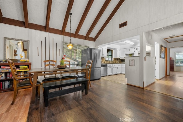 dining area with dark wood-type flooring, beam ceiling, and visible vents