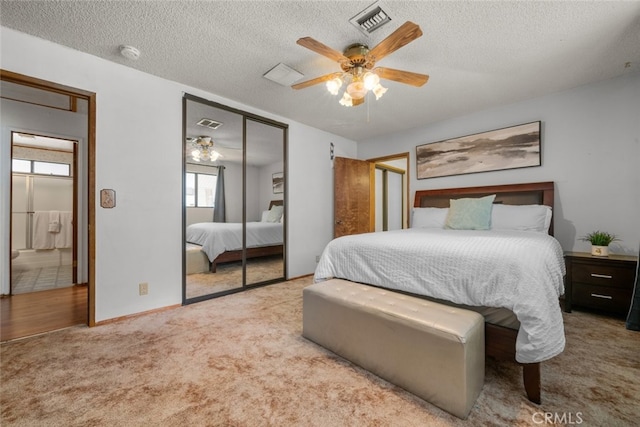 carpeted bedroom featuring a textured ceiling, a closet, and visible vents