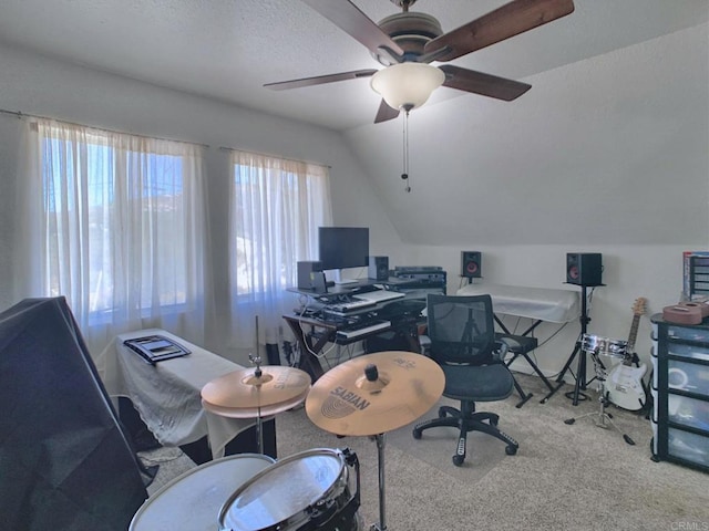 carpeted office space featuring lofted ceiling, a textured ceiling, and ceiling fan