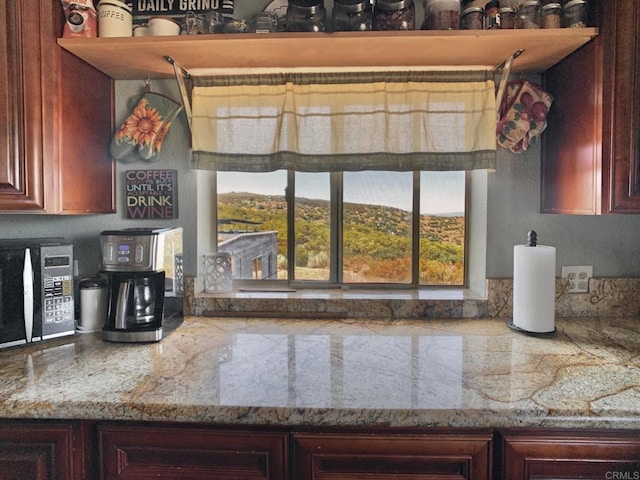 kitchen featuring a mountain view and light stone countertops