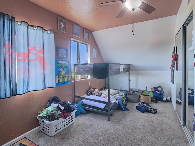 interior space featuring lofted ceiling, a textured ceiling, carpet flooring, and ceiling fan