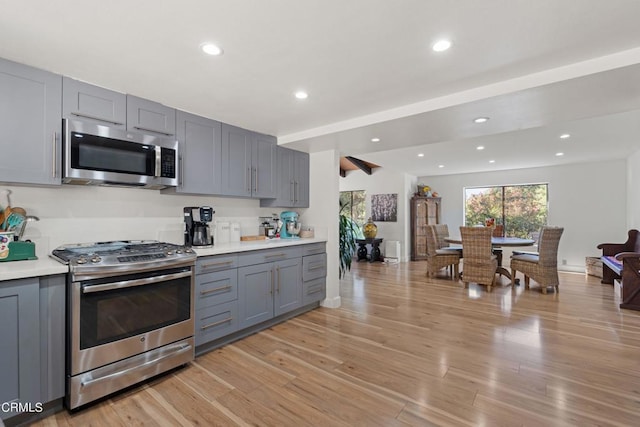 kitchen featuring light hardwood / wood-style flooring, stainless steel appliances, and gray cabinetry