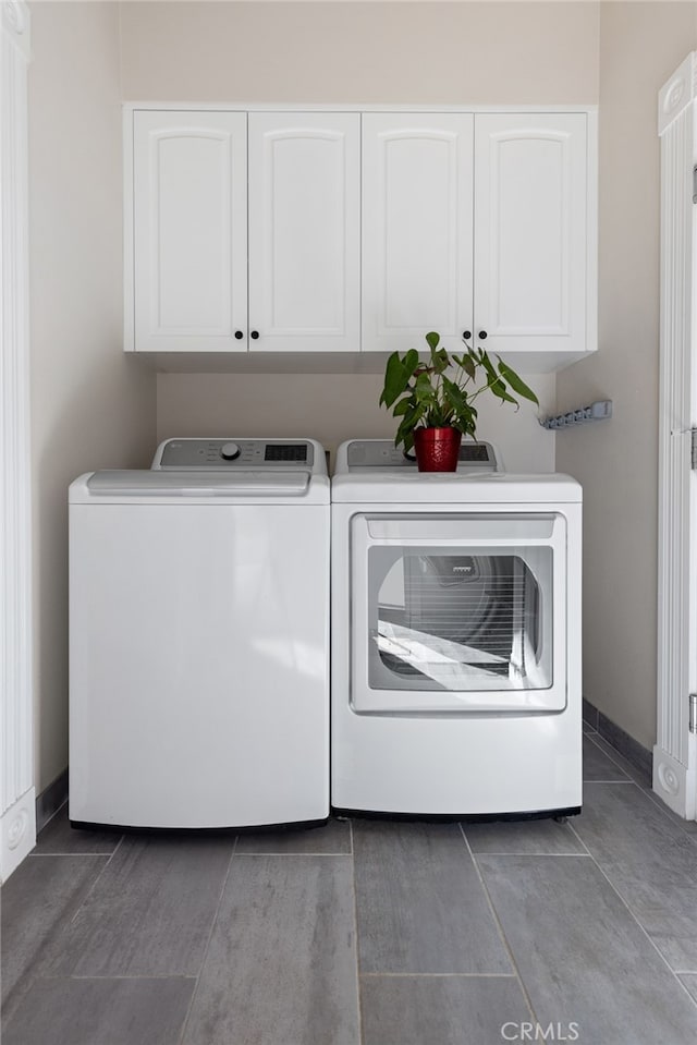 washroom with washer and dryer and cabinets