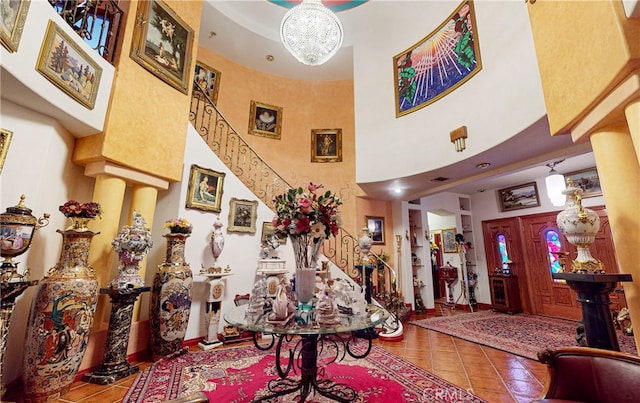 tiled foyer entrance featuring an inviting chandelier and a high ceiling