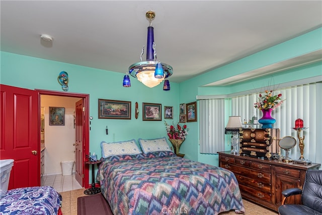 bedroom featuring ensuite bath and light tile patterned floors