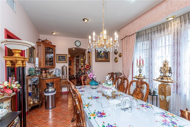 dining space with tile patterned flooring and an inviting chandelier