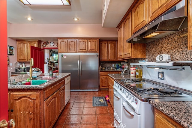 kitchen featuring tasteful backsplash, white appliances, sink, extractor fan, and tile patterned floors