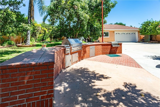 view of front of property with area for grilling, sink, and a garage