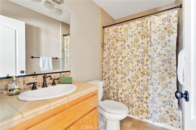 bathroom featuring decorative backsplash, tile patterned floors, toilet, and vanity