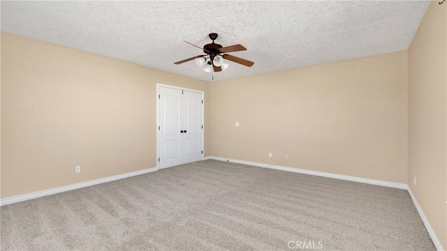 carpeted empty room with ceiling fan and a textured ceiling