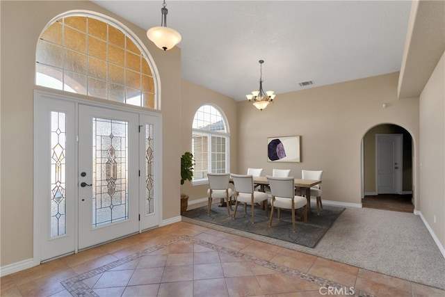 tiled entrance foyer featuring a chandelier