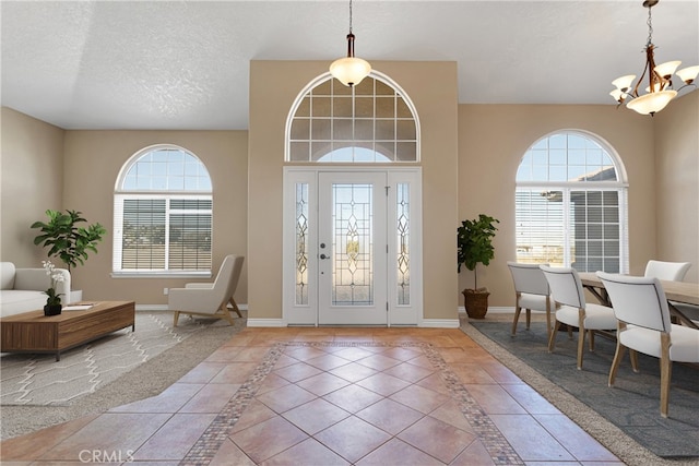 entryway featuring a notable chandelier, tile patterned floors, and a textured ceiling