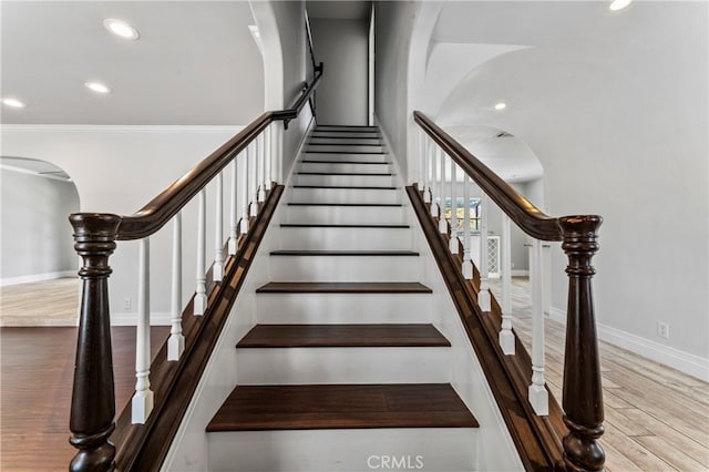 stairway with crown molding and hardwood / wood-style flooring