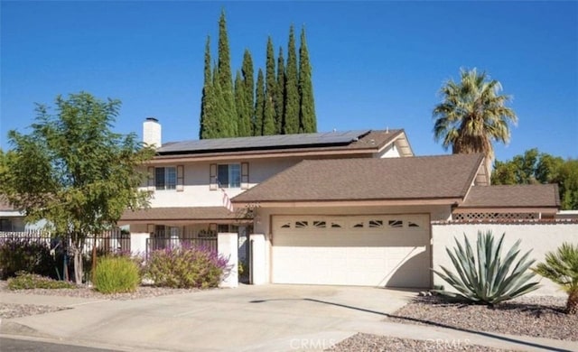 front of property featuring a garage and solar panels