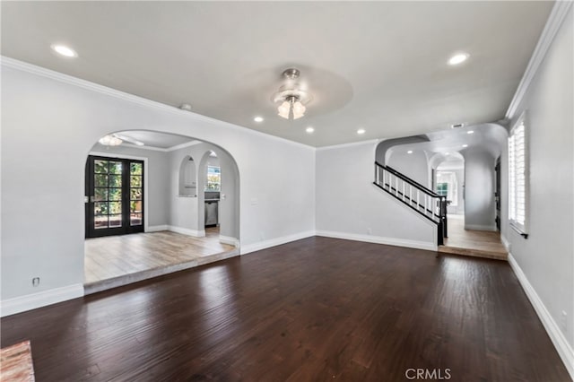 unfurnished living room featuring ornamental molding, ceiling fan, and dark wood-type flooring