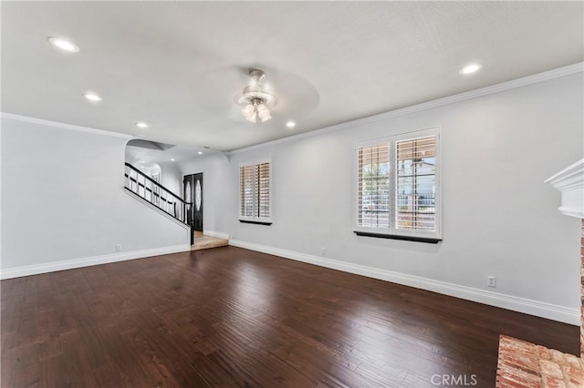 unfurnished living room with ceiling fan, dark wood-type flooring, and crown molding