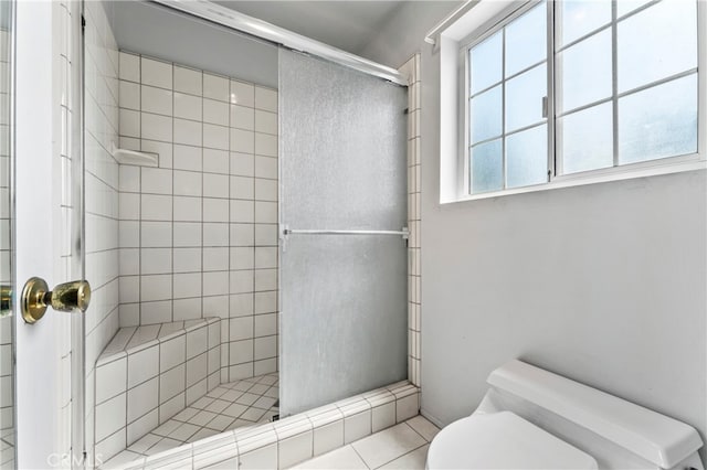 bathroom featuring tile patterned flooring, an enclosed shower, and toilet