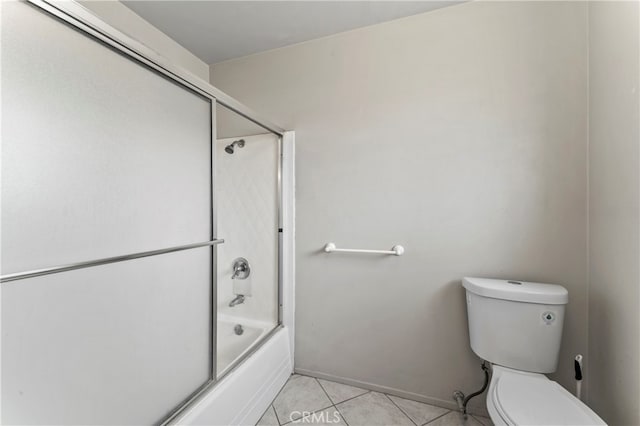 bathroom featuring combined bath / shower with glass door, toilet, and tile patterned flooring