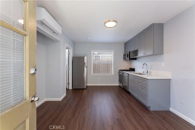 kitchen featuring sink, gray cabinets, a wall mounted AC, and appliances with stainless steel finishes