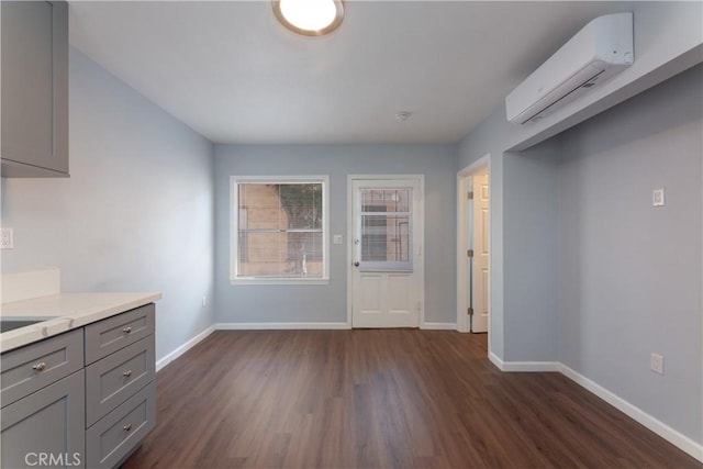 unfurnished dining area featuring dark wood-type flooring and a wall mounted AC