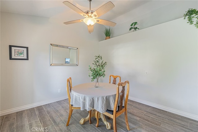 dining room with vaulted ceiling, ceiling fan, and dark wood-type flooring