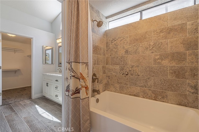 bathroom featuring tiled shower / bath, vanity, and a textured ceiling