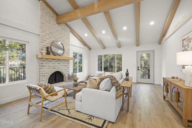 living room featuring light hardwood / wood-style flooring, high vaulted ceiling, beamed ceiling, and a brick fireplace