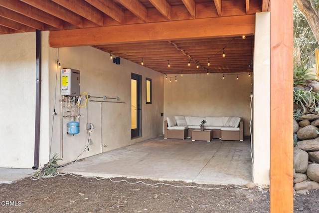 view of patio with outdoor lounge area and tankless water heater