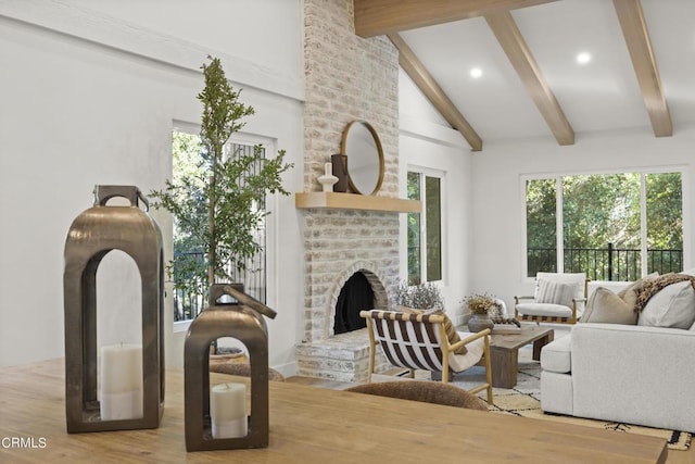 living room with beamed ceiling, high vaulted ceiling, a brick fireplace, and hardwood / wood-style flooring