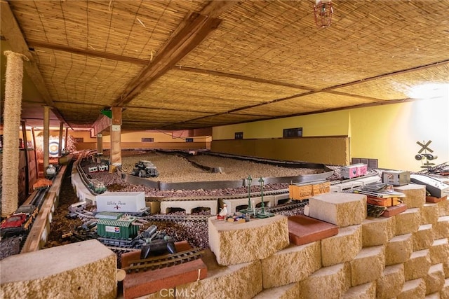 interior space featuring a bowling alley and beamed ceiling