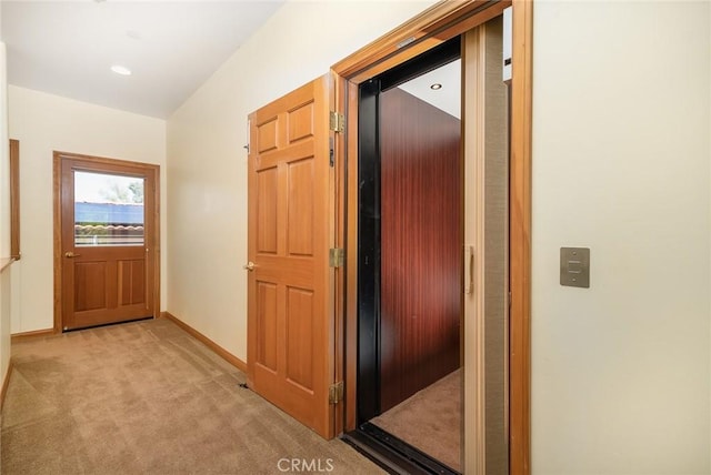 hall with elevator and light carpet