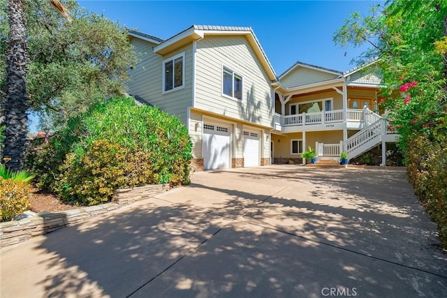 rear view of property featuring a garage and covered porch