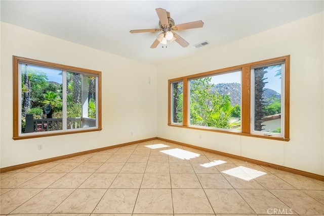 tiled empty room featuring ceiling fan