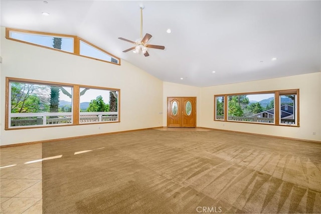 unfurnished living room featuring ceiling fan, light colored carpet, and vaulted ceiling