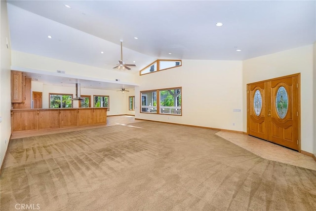 unfurnished living room with high vaulted ceiling, light colored carpet, and ceiling fan