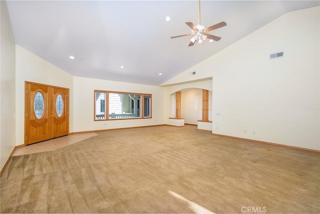 unfurnished living room featuring high vaulted ceiling, ceiling fan, and light colored carpet