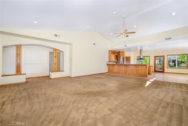 unfurnished living room featuring light colored carpet, ceiling fan, and vaulted ceiling