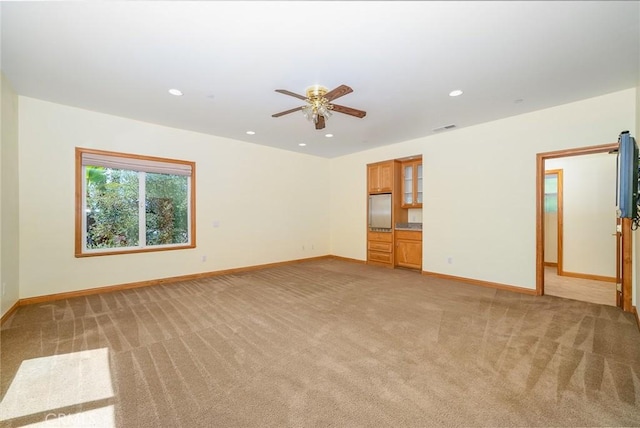 spare room featuring ceiling fan and light carpet