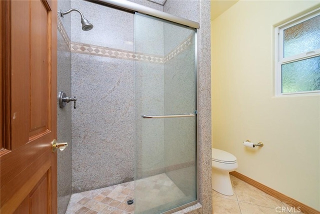 bathroom featuring toilet, tile patterned floors, and a shower with shower door