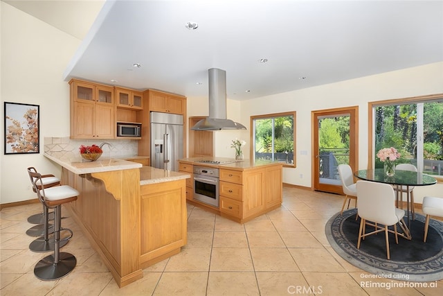 kitchen with stainless steel appliances, light tile patterned flooring, kitchen peninsula, backsplash, and island range hood