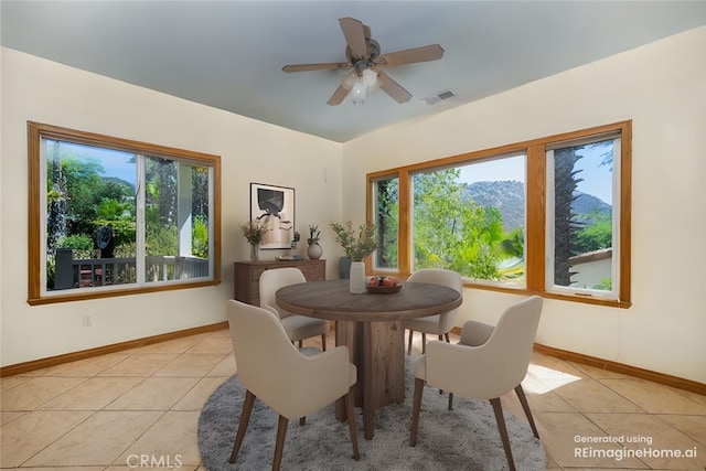 tiled dining space featuring ceiling fan and a healthy amount of sunlight