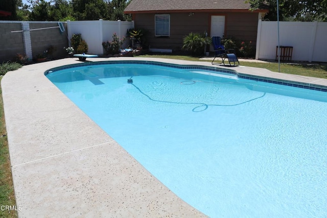 view of swimming pool with a diving board